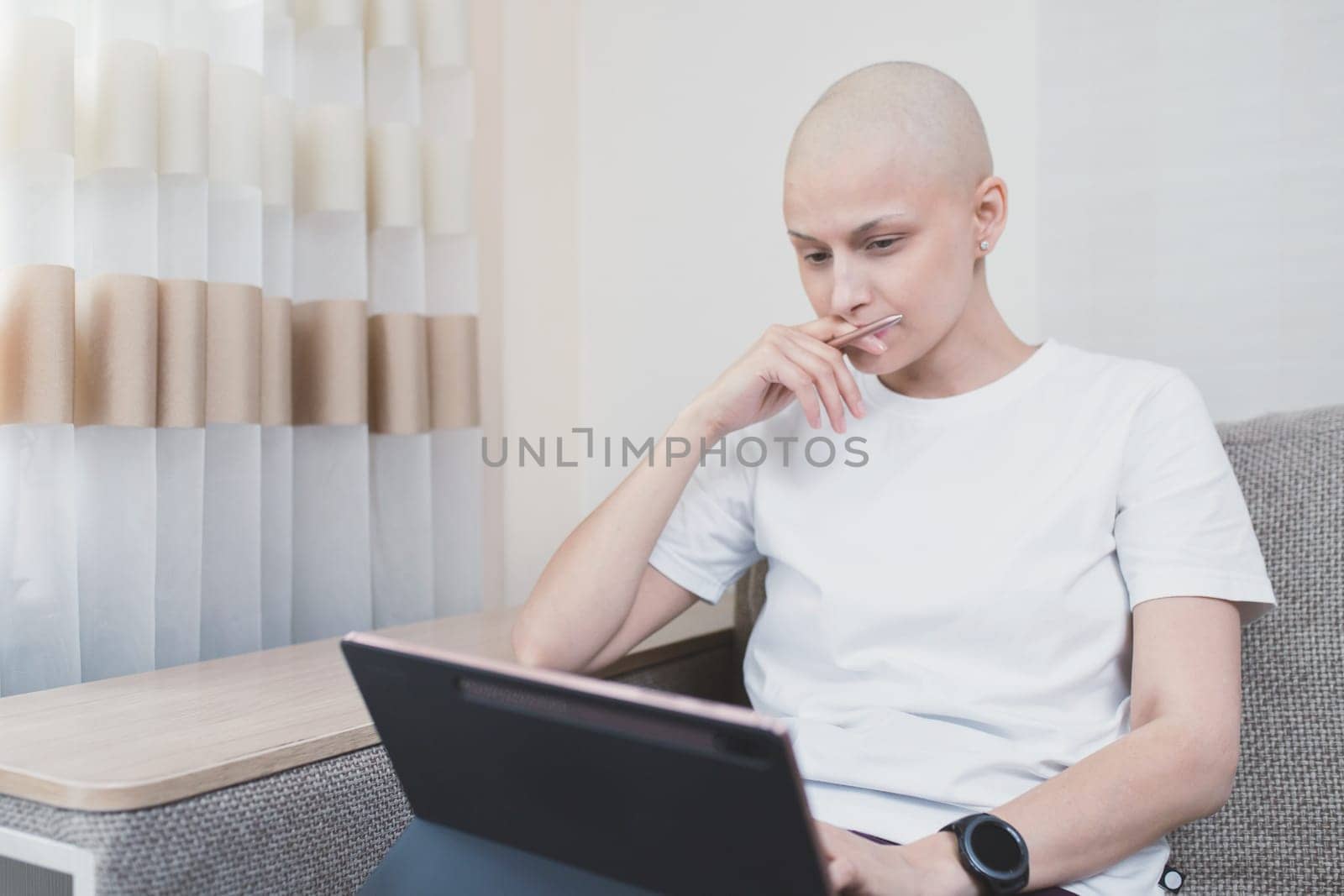 Woman with oncology after chemotherapy working remotely at home by Rom4ek