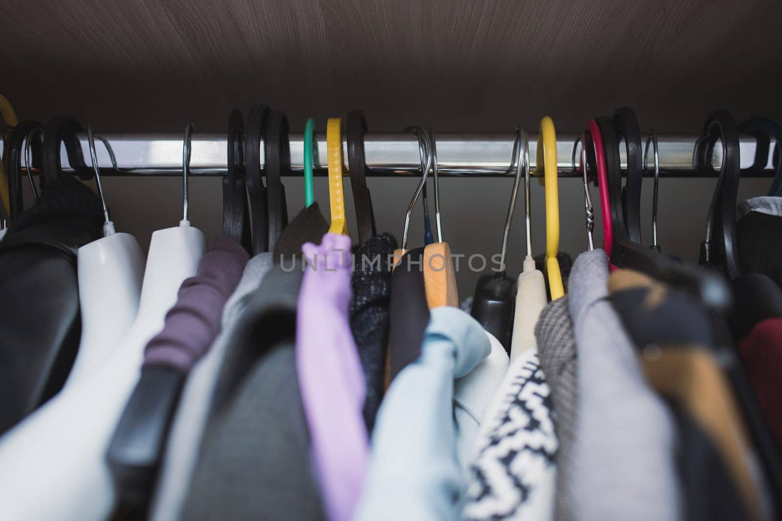 Various clothes randomly hanging on different hangers, close-up by Rom4ek