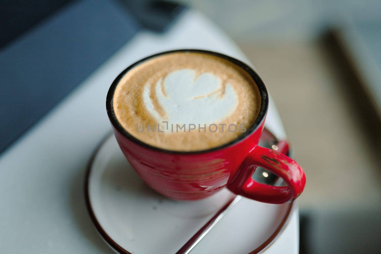 Red cup of coffee, cappuccino with heart shape, drink to good morning.
