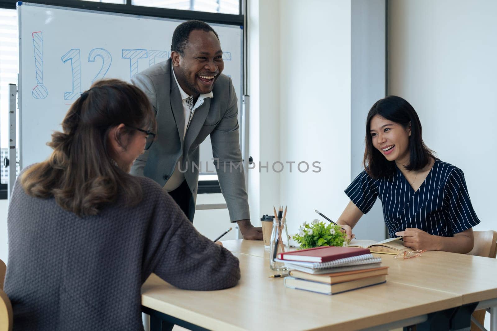 Mature professor talking to his student while assisting her on a class at the university.