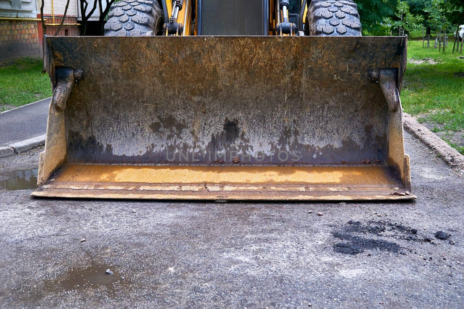 Excavator road grader bucket on asphalt at road repair by jovani68