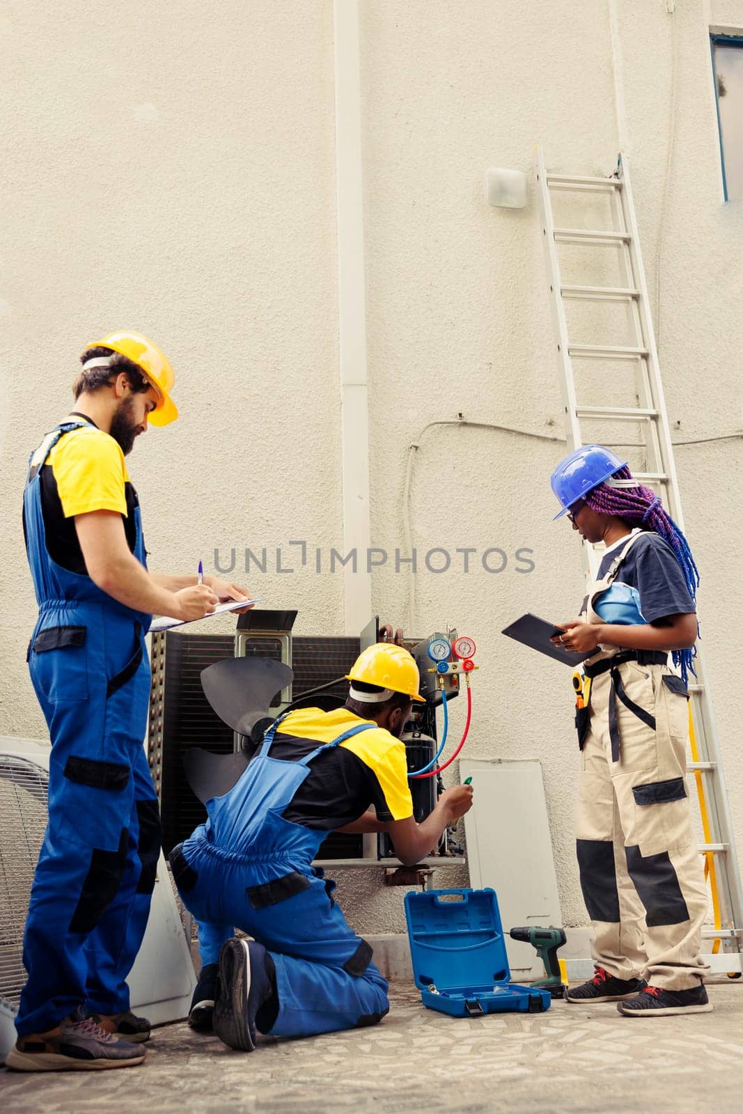 Diverse crew of certified technicians working outside, checking for obstructed air filters hampering hvac unit airflow, causing cooling system to work harder and consume more energy