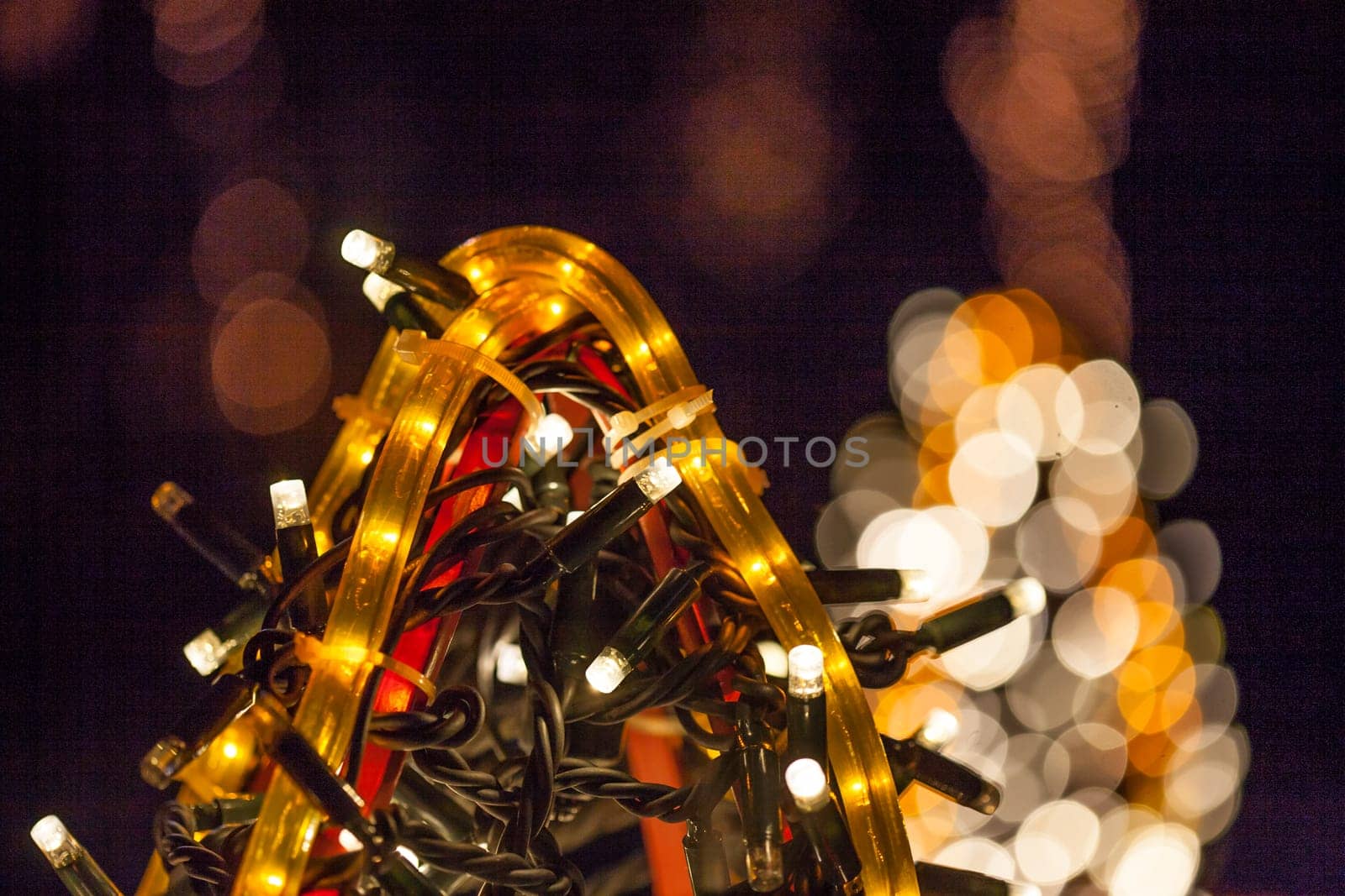 Occasional glowing Christmas and New Year decorations hang in the square, shot at night
