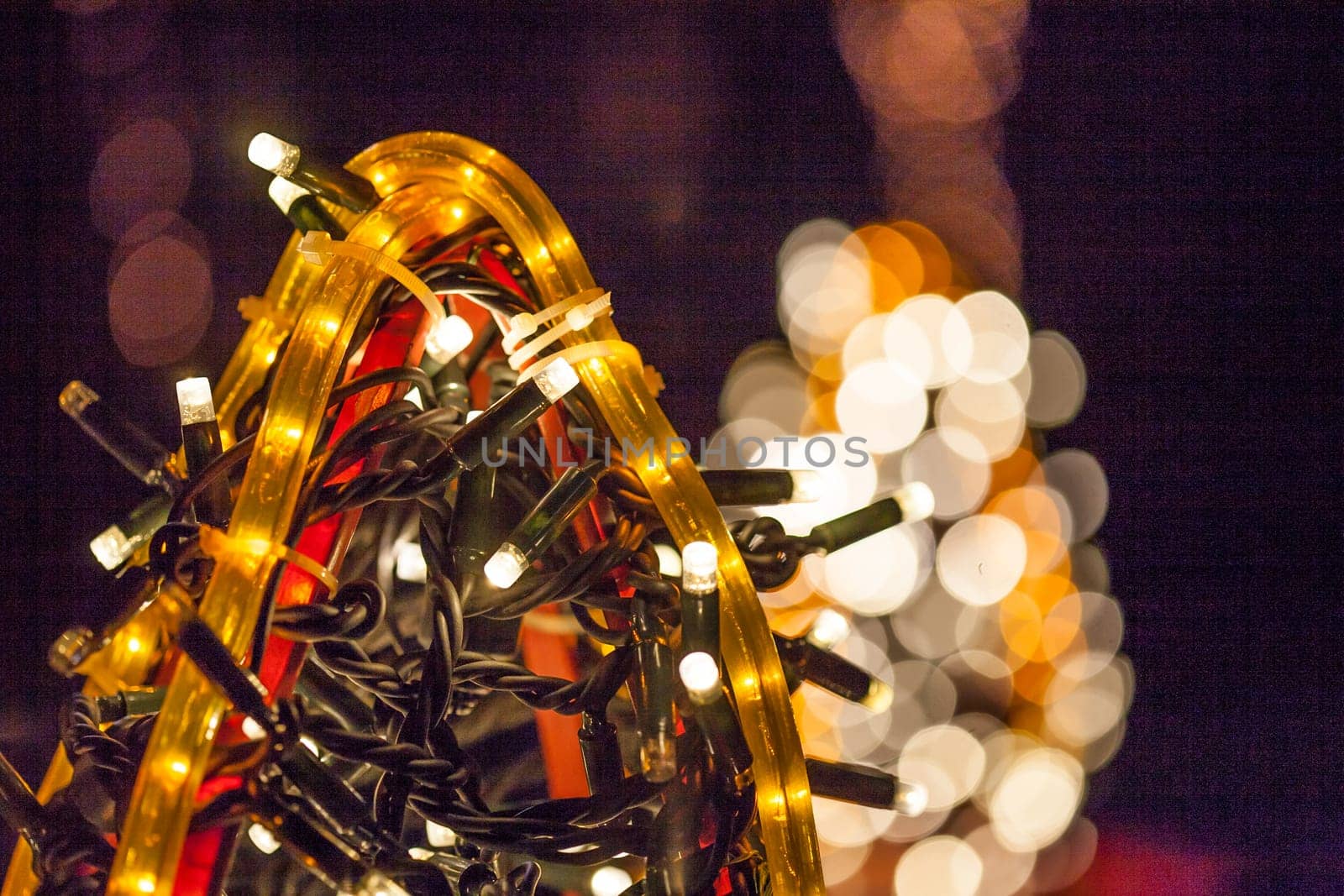 Occasional glowing Christmas and New Year decorations hang in the square, shot at night
