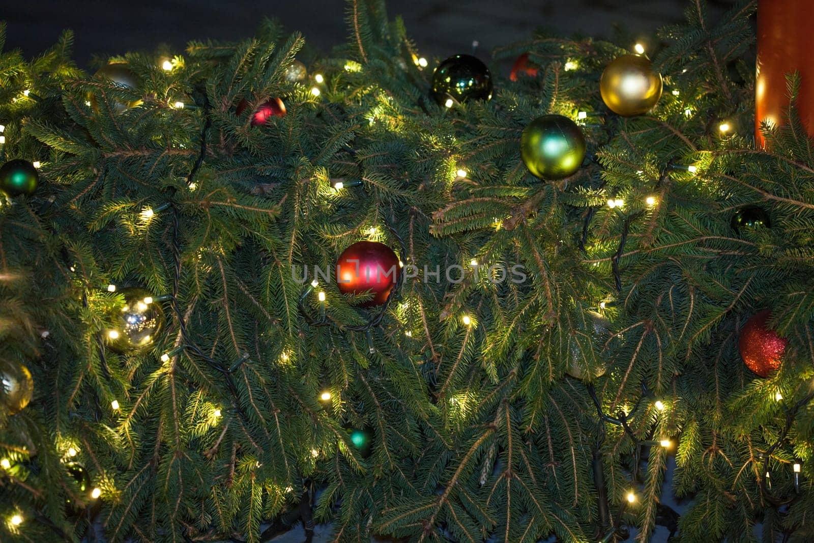 Occasional glowing Christmas and New Year decorations hang in the square, shot at night
