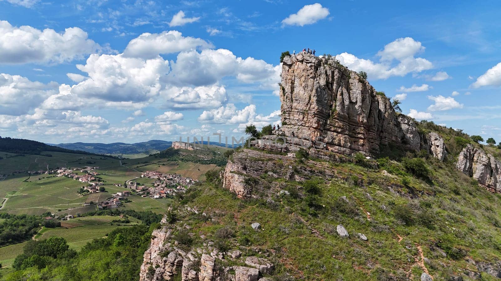 Saone et Loire,France,25-05-2024: , Solutre Pouilly, people and mountain climbers climb the rock of Solutre and vineyard fall