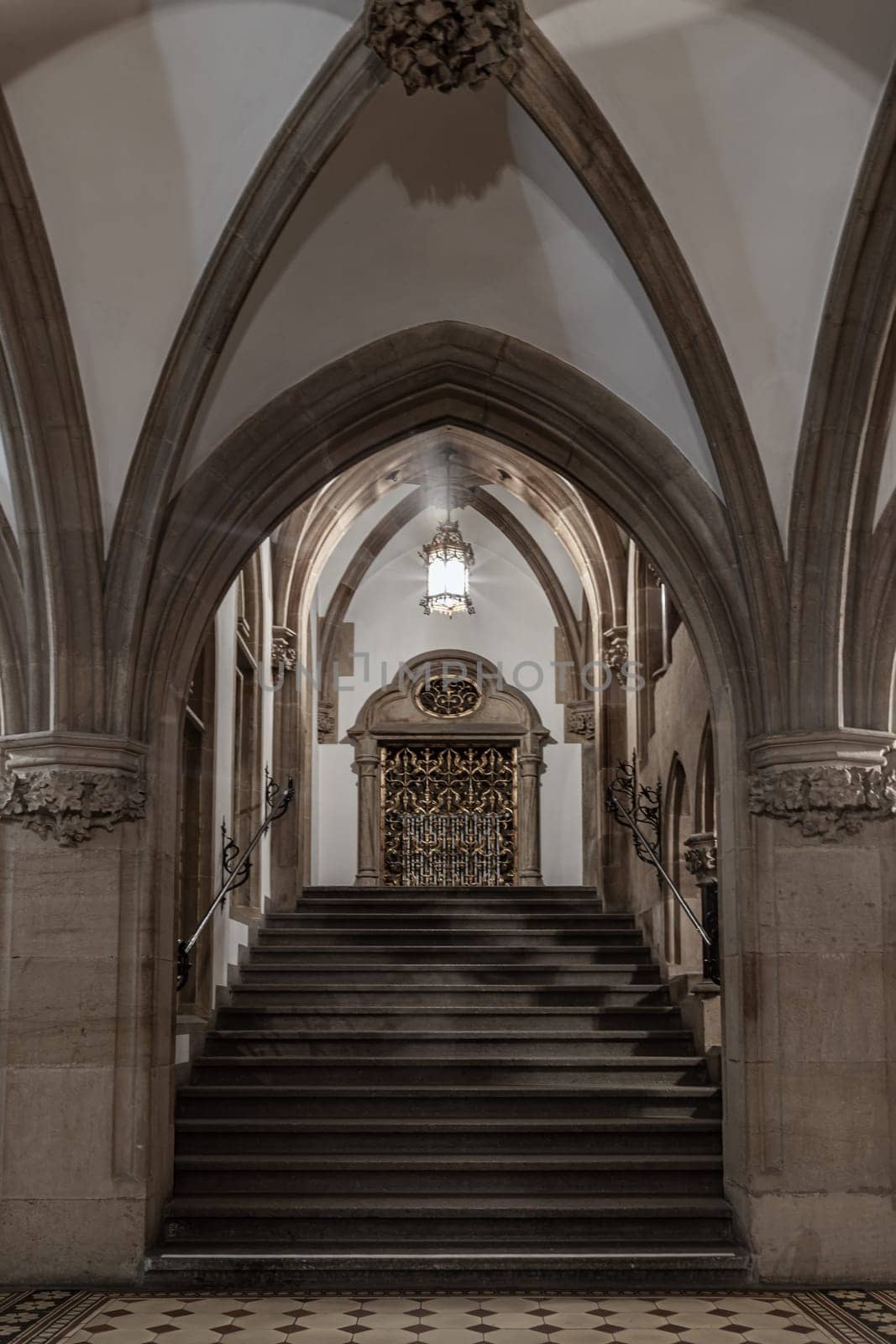 Munich, Germany - Dec 21, 2023 - Gothic architectural style with arches of famous New Town Hall (Neues Rathaus) on Marienplatz square in Munich. Beautiful Corridor with Staircase, Ceiling, Pillars and Lamp, Space for text, Selective focus.