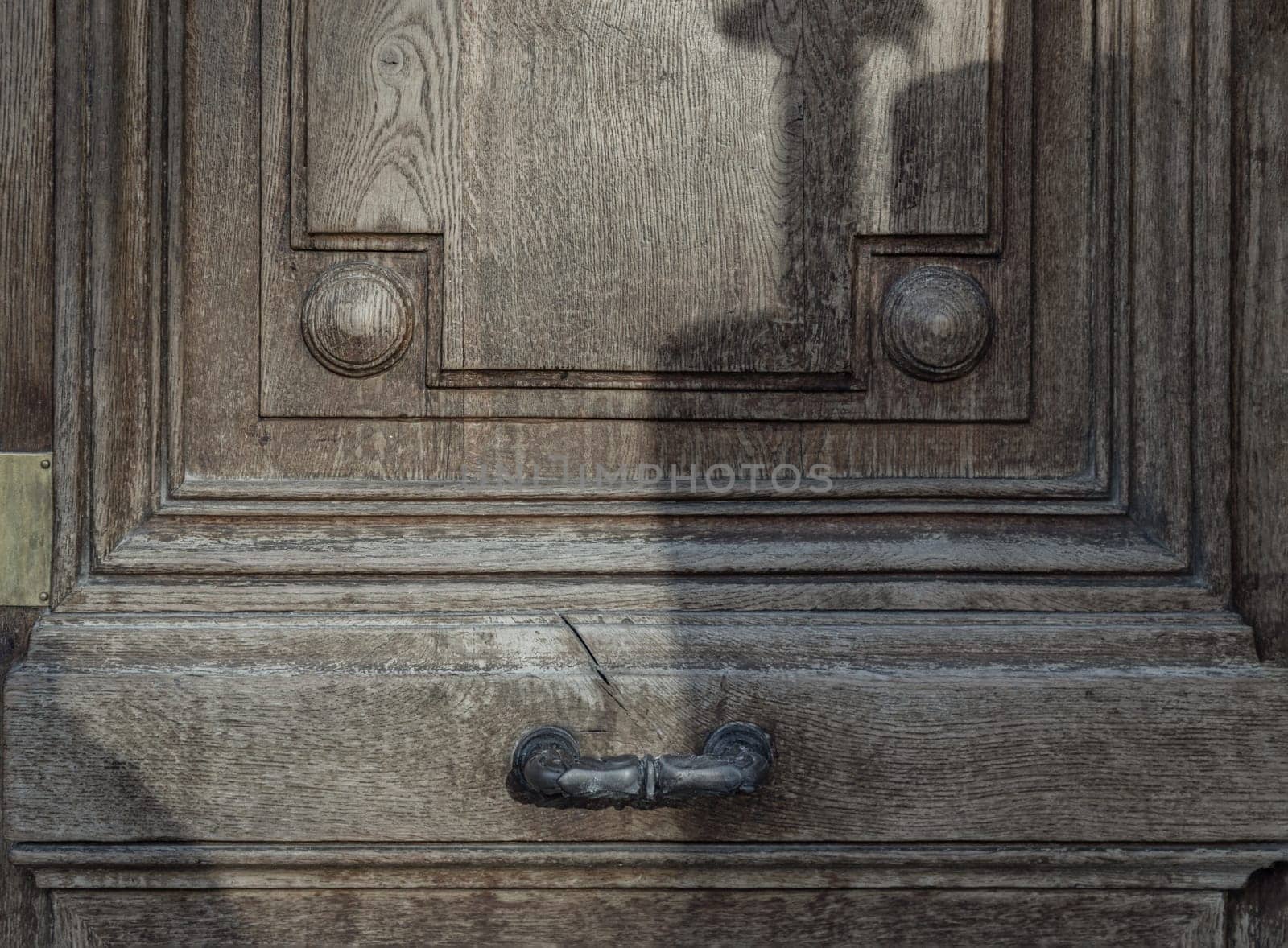 Metal door handle on Brown old wooden door. Traditional wooden entrance door with Old metal door handle, Space for text, Selective focus.