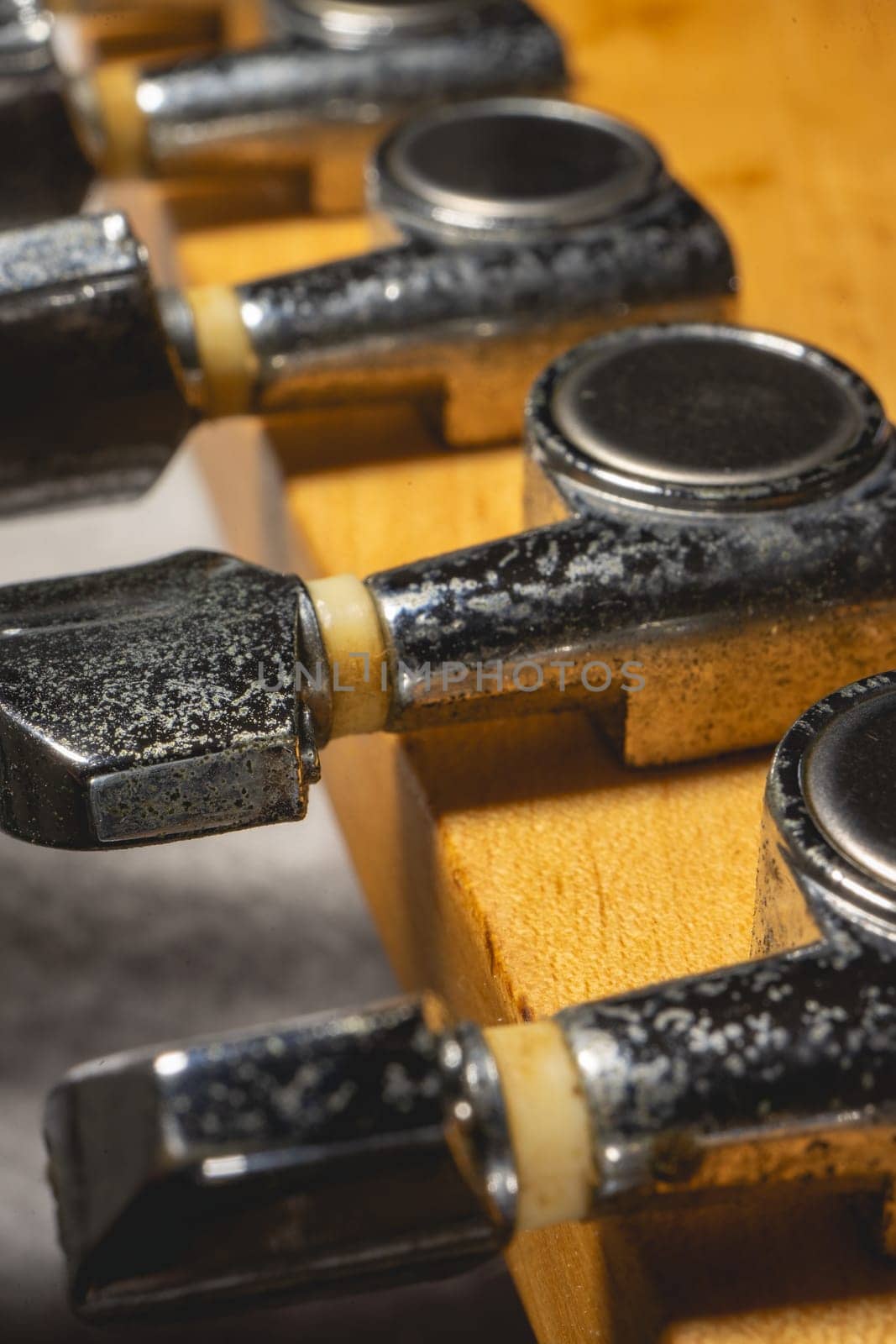 Close up from a Headstock of a guitar made of Maple wood, and some silver color tuners.