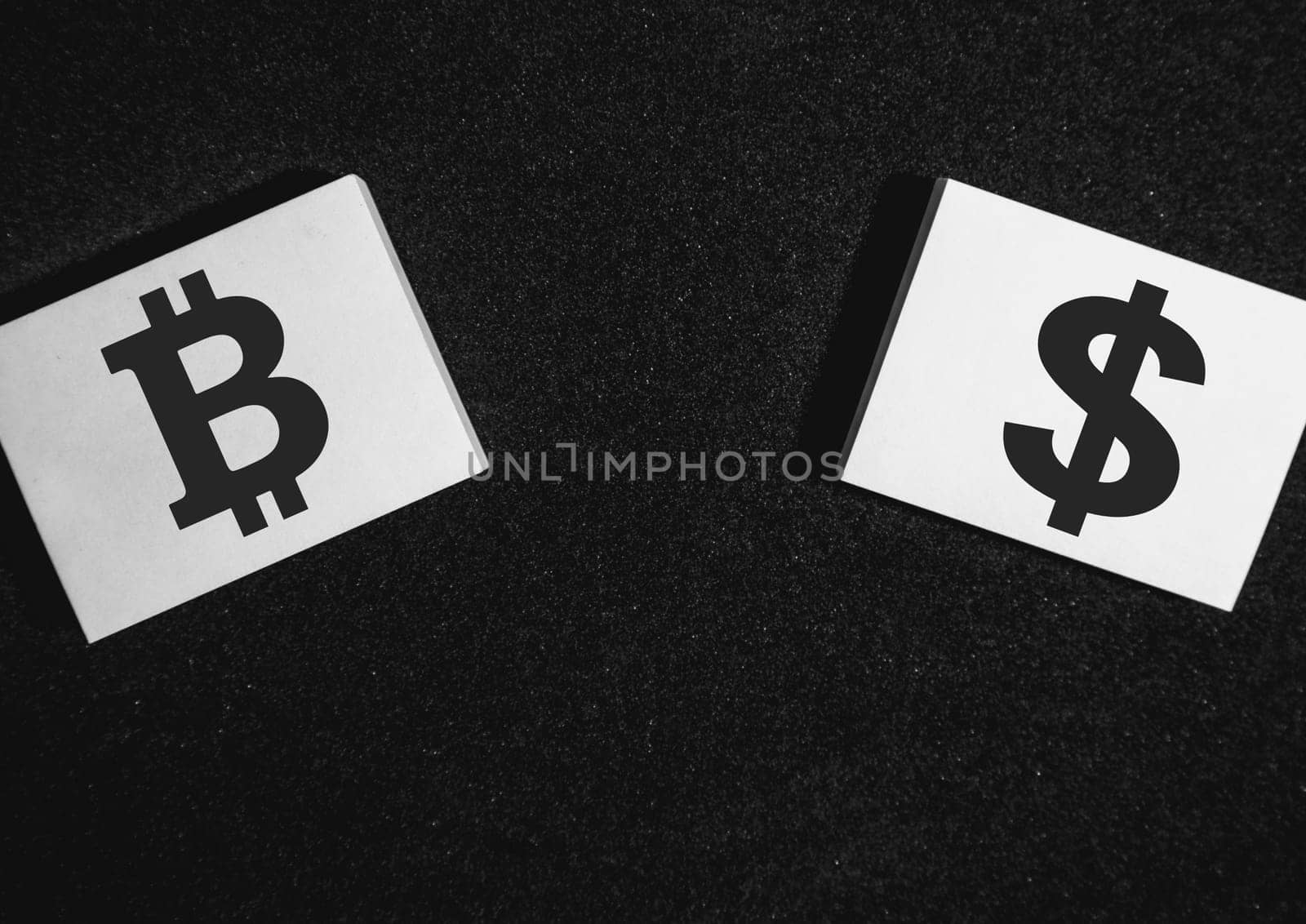 Two sticky notes on a black background with a bitcoin and a dollar on it.