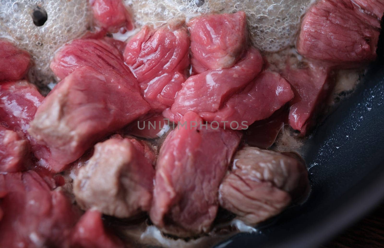 Top view of pieces of pork fried in pan, traditional meat dish. Hungarian goulash or pork stew. Cooking food concept
