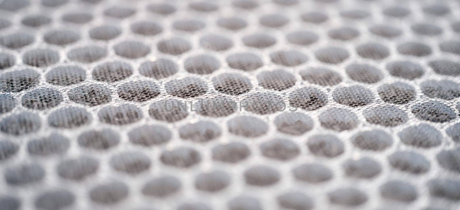 Close-up of multi-stage air filter with uv radiation and activated carbon granules. Replaceable carbon air purifier filter. Hepa filter surface background