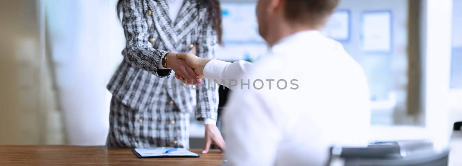 Close-up of business partners shaking hands after making good deal. Colleagues handshaking after bargaining or successful agreement. Contract concept
