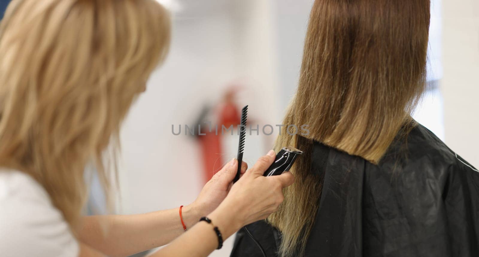 Close-up of process of hair cutting at beauty salon, using hair clipper. Beauty day, making haircut