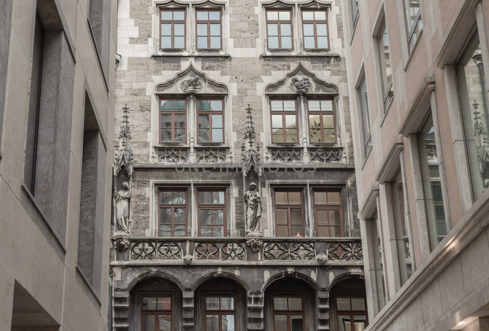 Munich, Germany - Dec 21, 2023 - Exterior design of famous New Town Hall (Neue Rathaus) on Marienplatz square in Munich. Sandstone Building with many windows is decorated with statues and gothic architecture style, Copy space, Selective focus.