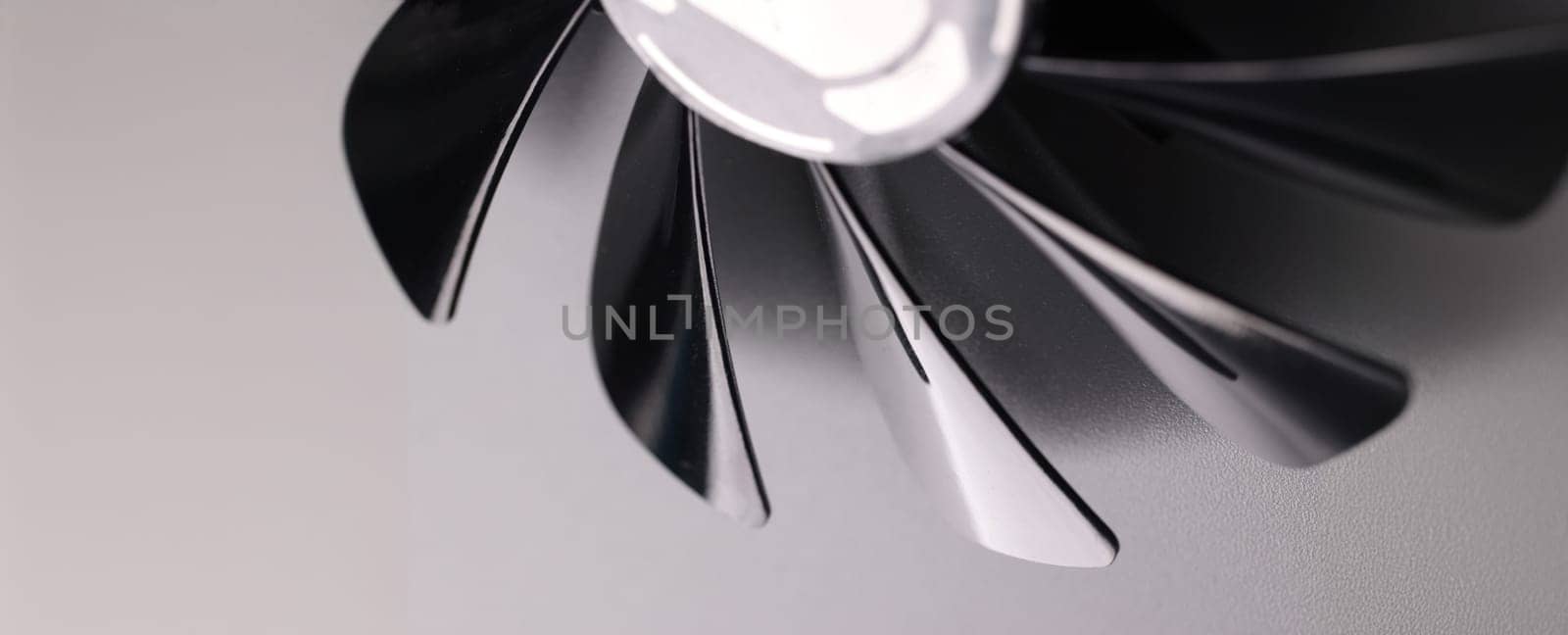 Close-up of cooling fan with black plastic blades on grey background. Car details parts. Device for cooling or ventilation
