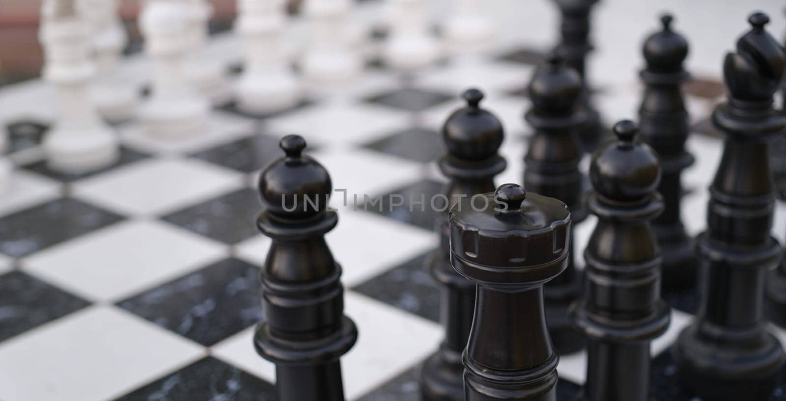 Close-up of chessboard with chessmen, chess battle white against black. Board and strategy game. Creative teamwork company business concept