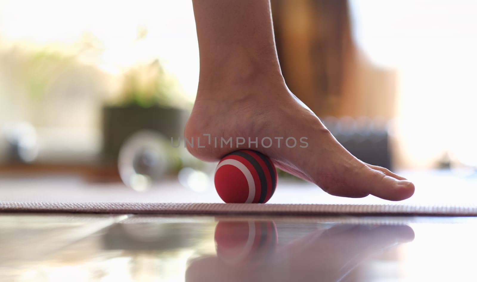 Close-up of myofascial release of hyper-movable muscles of foot with massage ball. Prevention of leg fatigue and foot disease concept