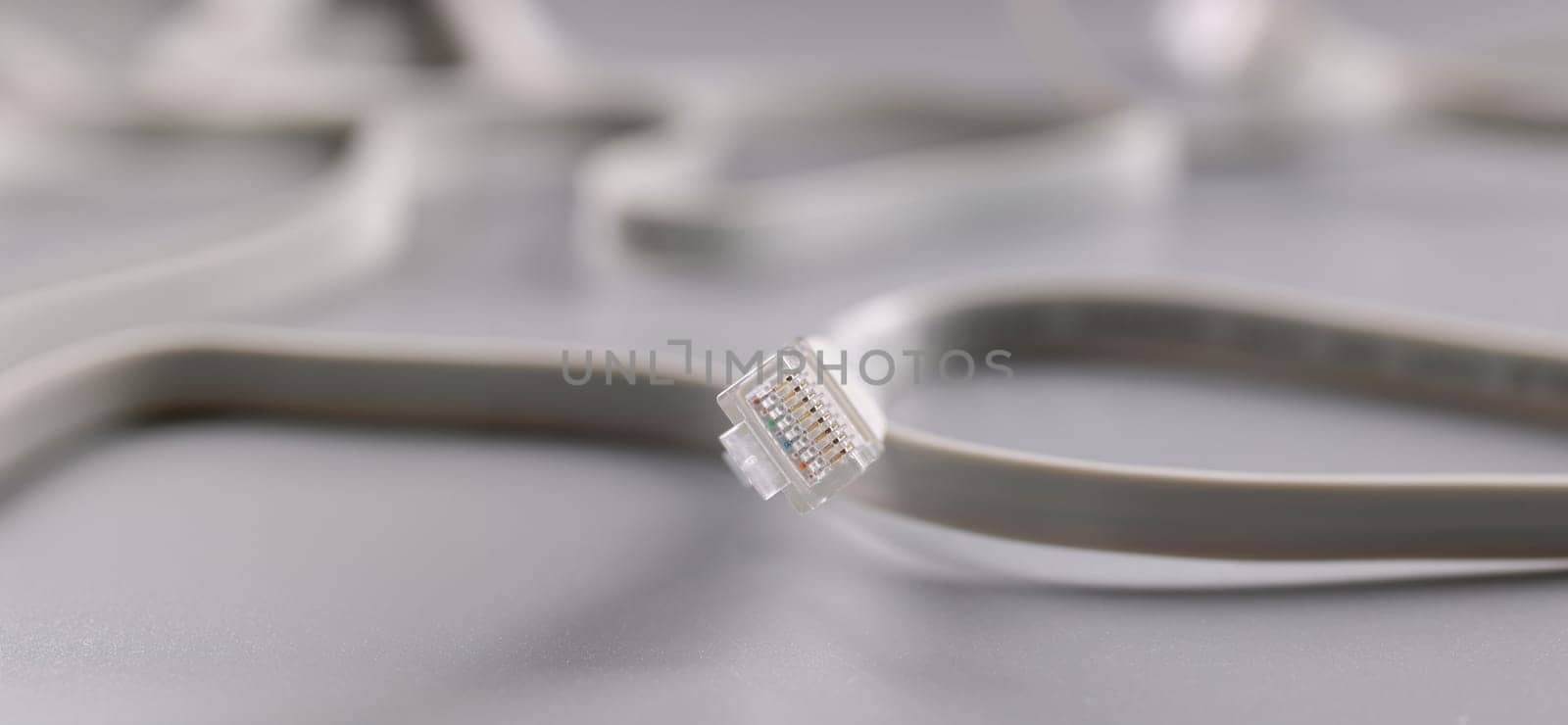 Close-up of internet connectors on grey background, cable with plastic clip. Internet and telecommunications, modern technology and service concept
