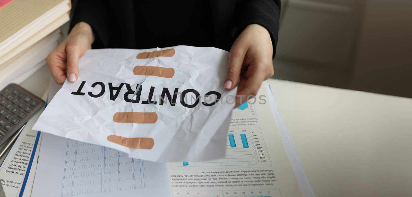 Close-up of torn sheet of paper with word contract glued with adhesive tape. Manager hands holding band-aid paper contract. Recovery contract agreement concept