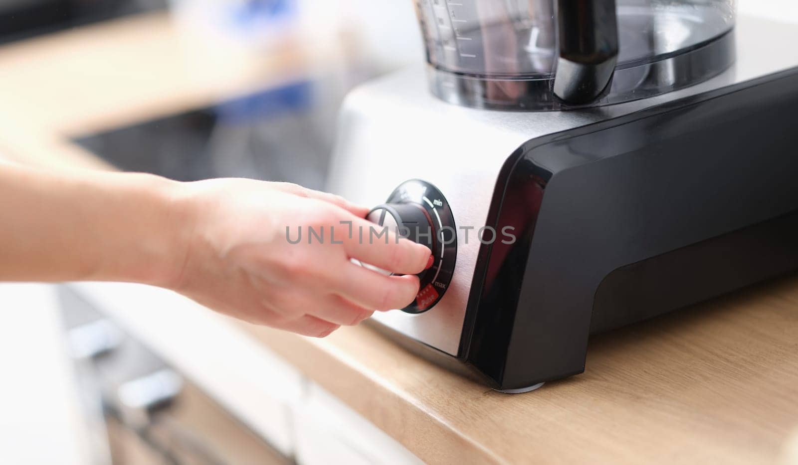 Close-up woman using blender to make tasty dish. Female hand touching speed controller. Cooking food concept