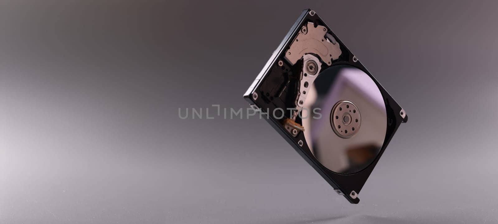 Close-up of computer hard disk drive with open cover. Hardware, hard disk and storage device. Detail of inside of hard disk drive