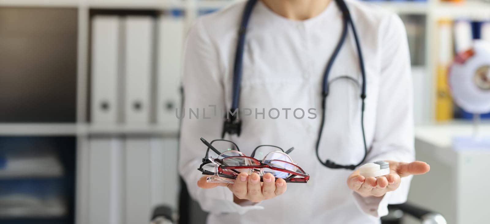 Close-up of female doctor making choice between contact lenses and glasses. Ophthalmologist, ophthalmology and vision correction concept