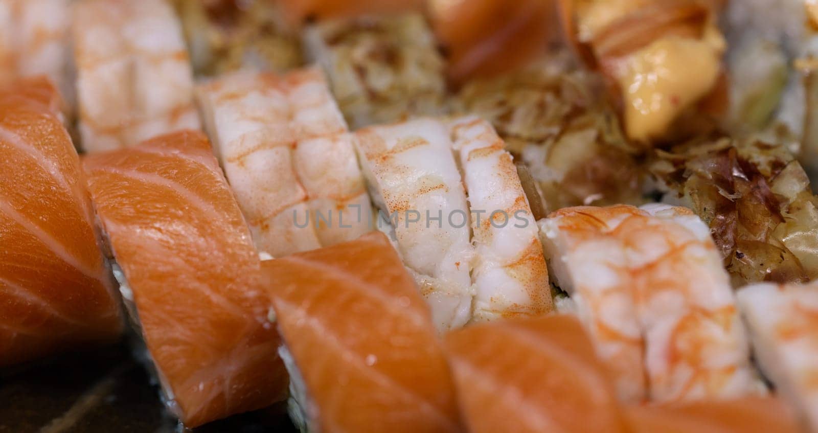 Top view of set of sushi rolls with salmon and shrimps, japanese traditional food. Sushi restaurant or cafe menu concept