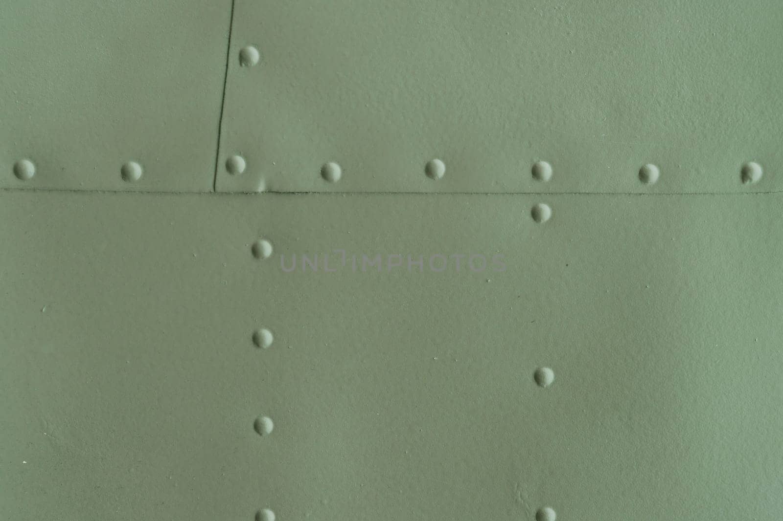 Protection of military equipment made of sheet metal with green rivets.