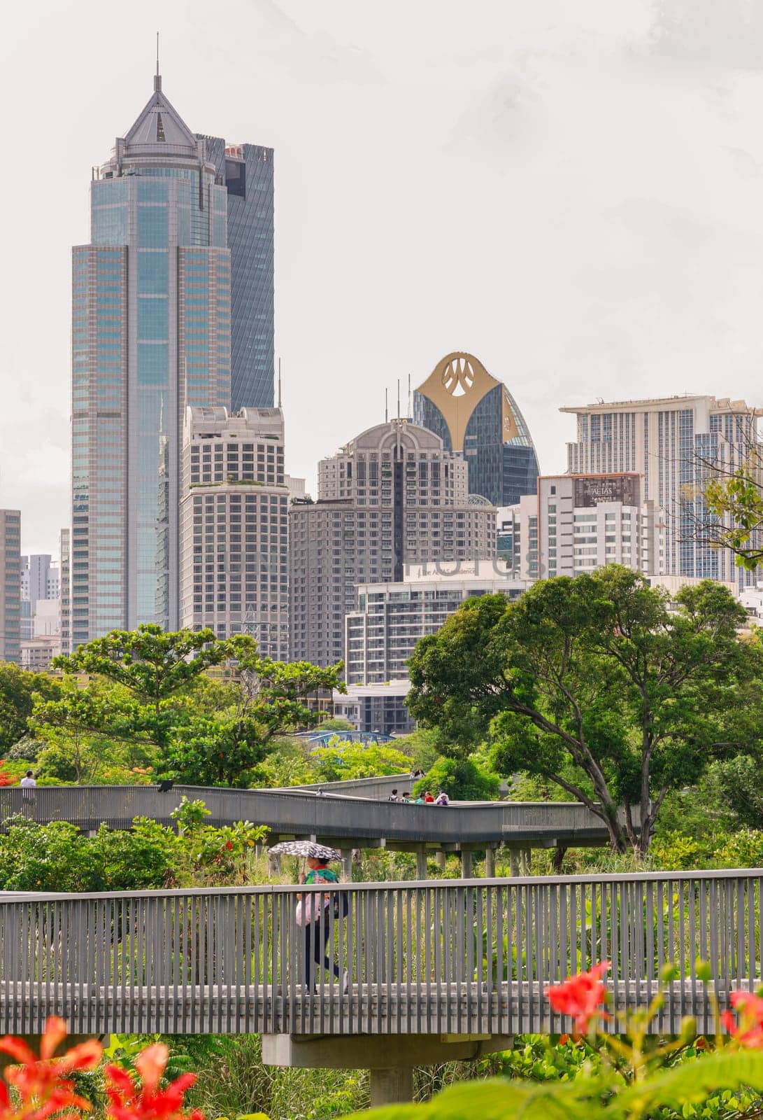 Bangkok, Thailand - 22 Jun, 2024 - Architecture view of Modern high-rise buildings on blue sky background and Benjakitti park skywalk in front. Picturesque cityscape view, Copy space, Selective focus.