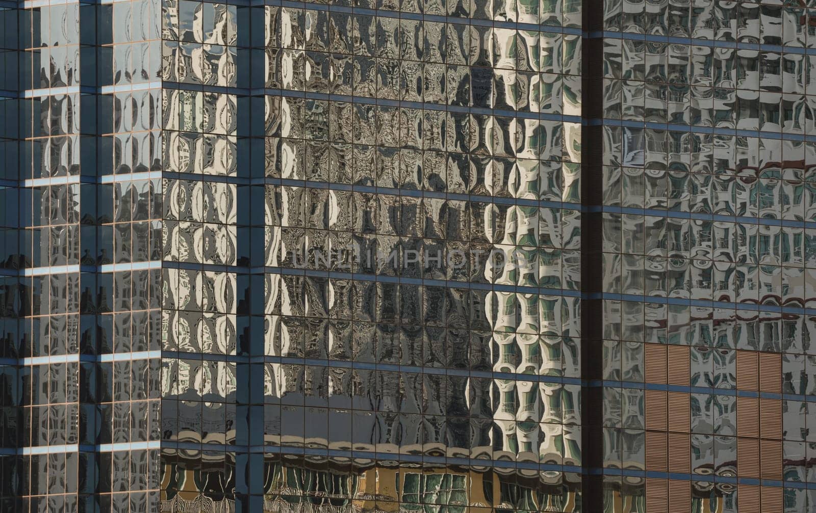 Bangkok, Thailand - 22 Jun, 2024 - Architectural exterior of modern office building facade with blue sky and clouds reflection in windows. Steel frame and glass windows architecture, Copy space, Selective focus.