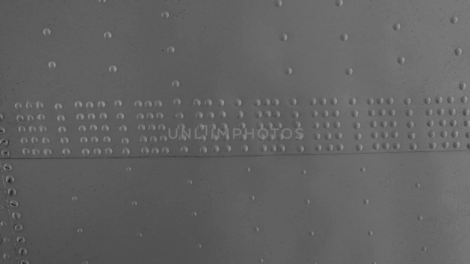 Metal wall with rivets. Metal surface with rivets, aircraft fuselage close-up.