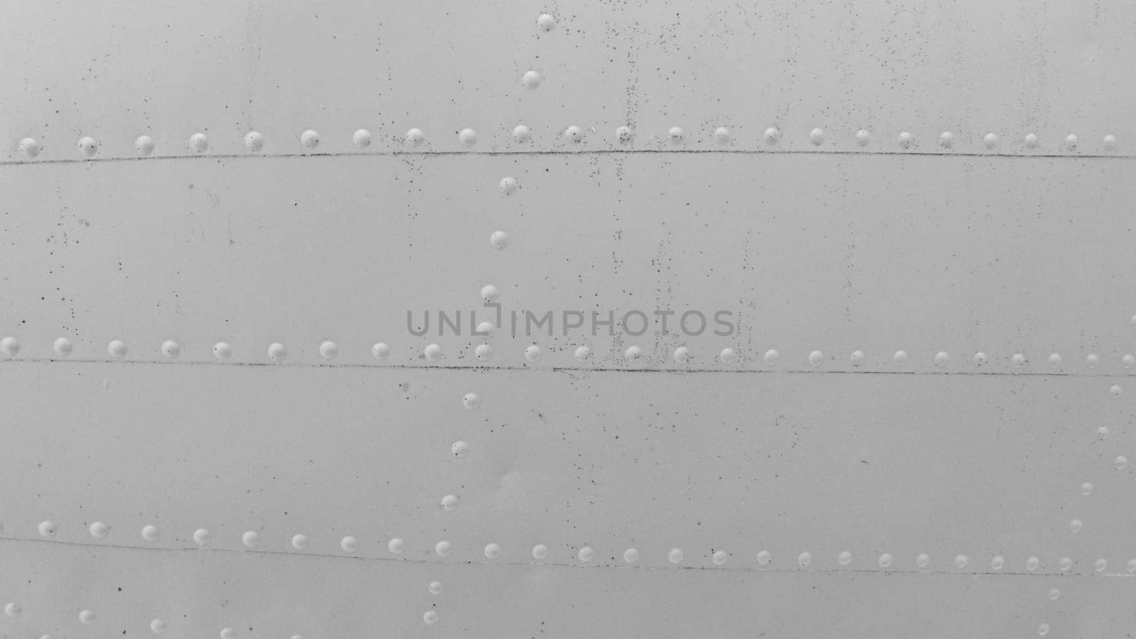 Photo of the metal skin of an old aircraft with rivets.