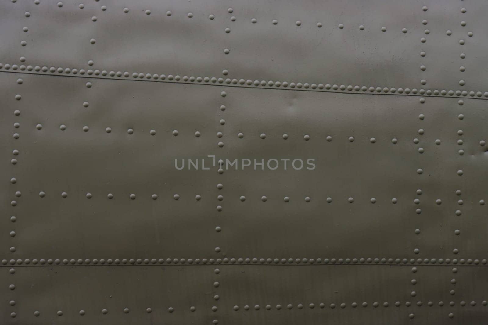Fragment of an airplane side with rivets.
