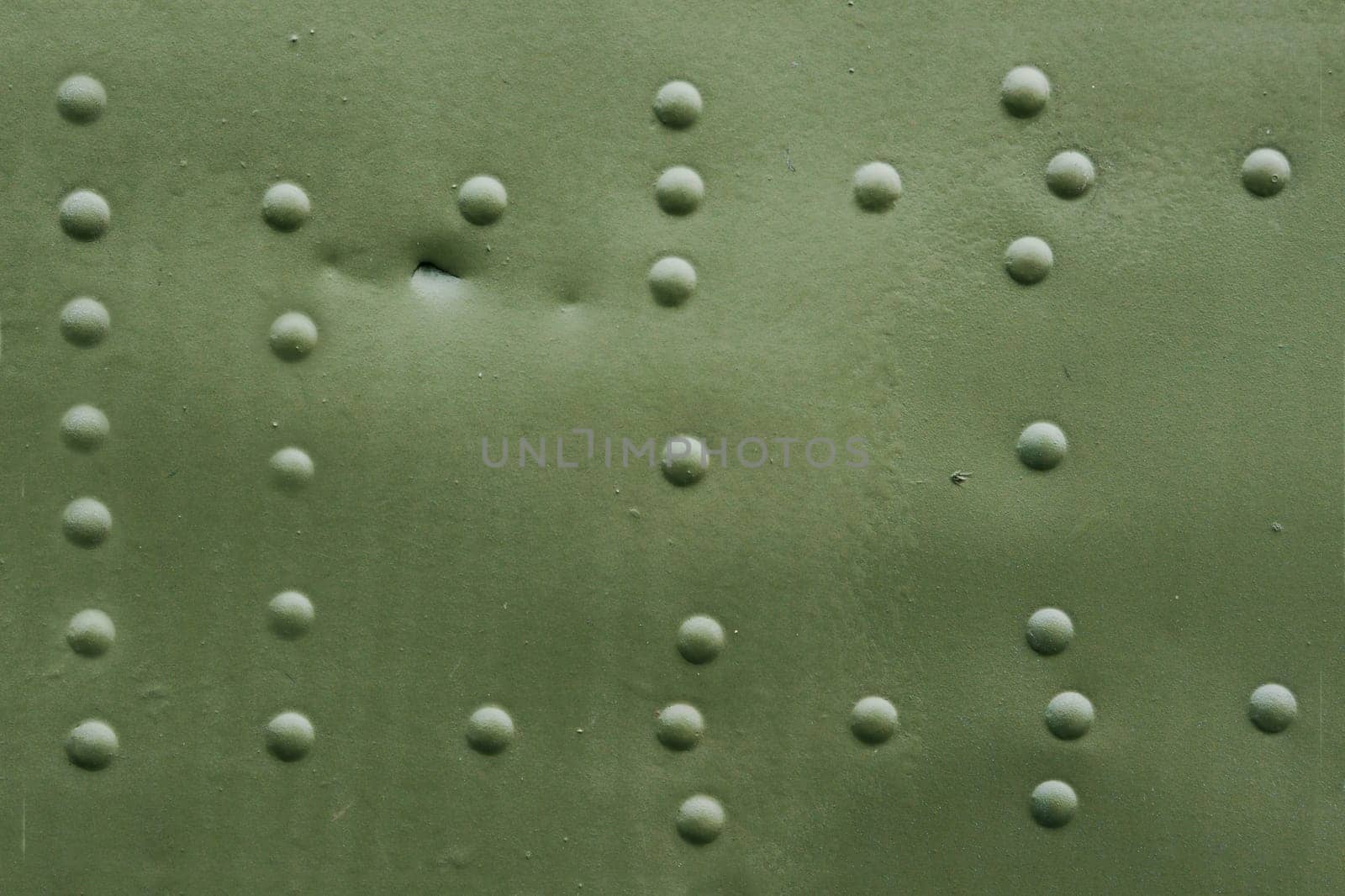 The surface of an old damaged aircraft skin with rivets.