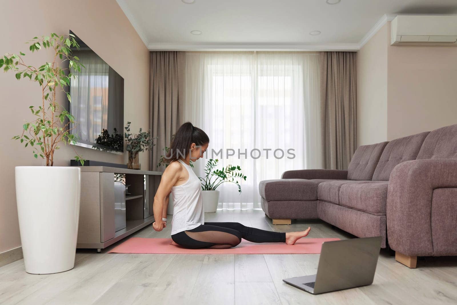 sporty woman stretching hands and warm up arm for exercise at home, online training