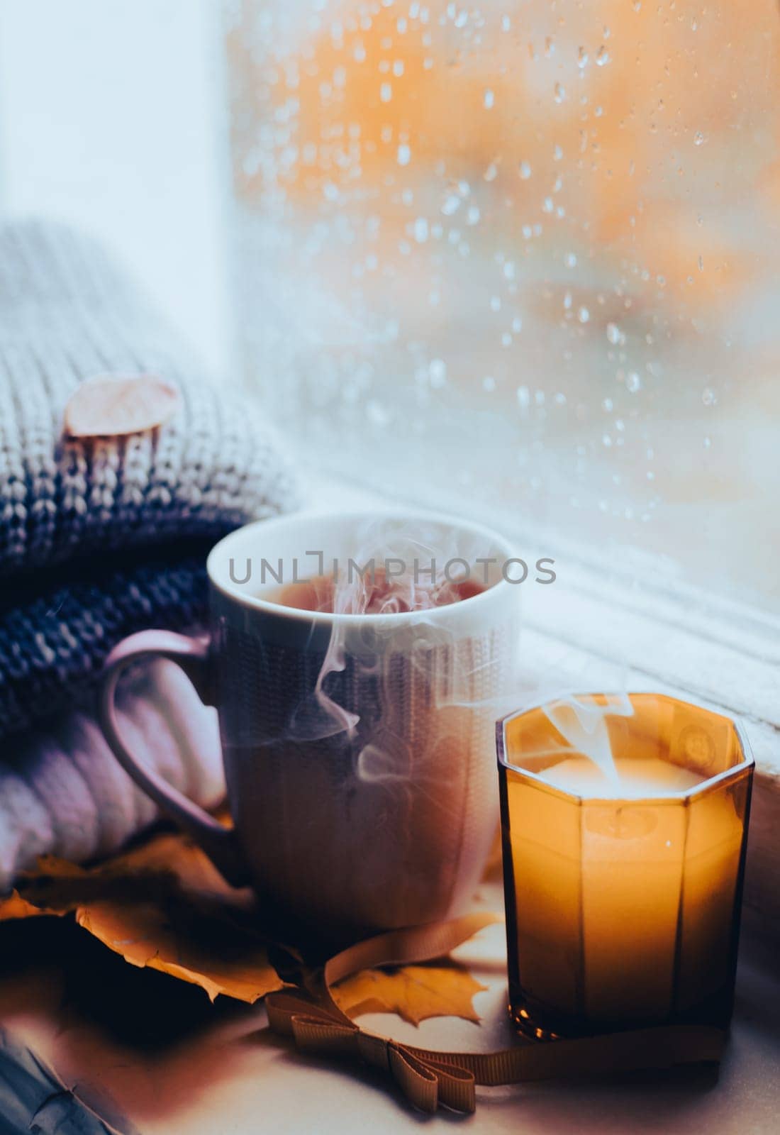 A burning candle on the window is autumn . the comfort of home . autumn comfort . autumn mood. The chondra .