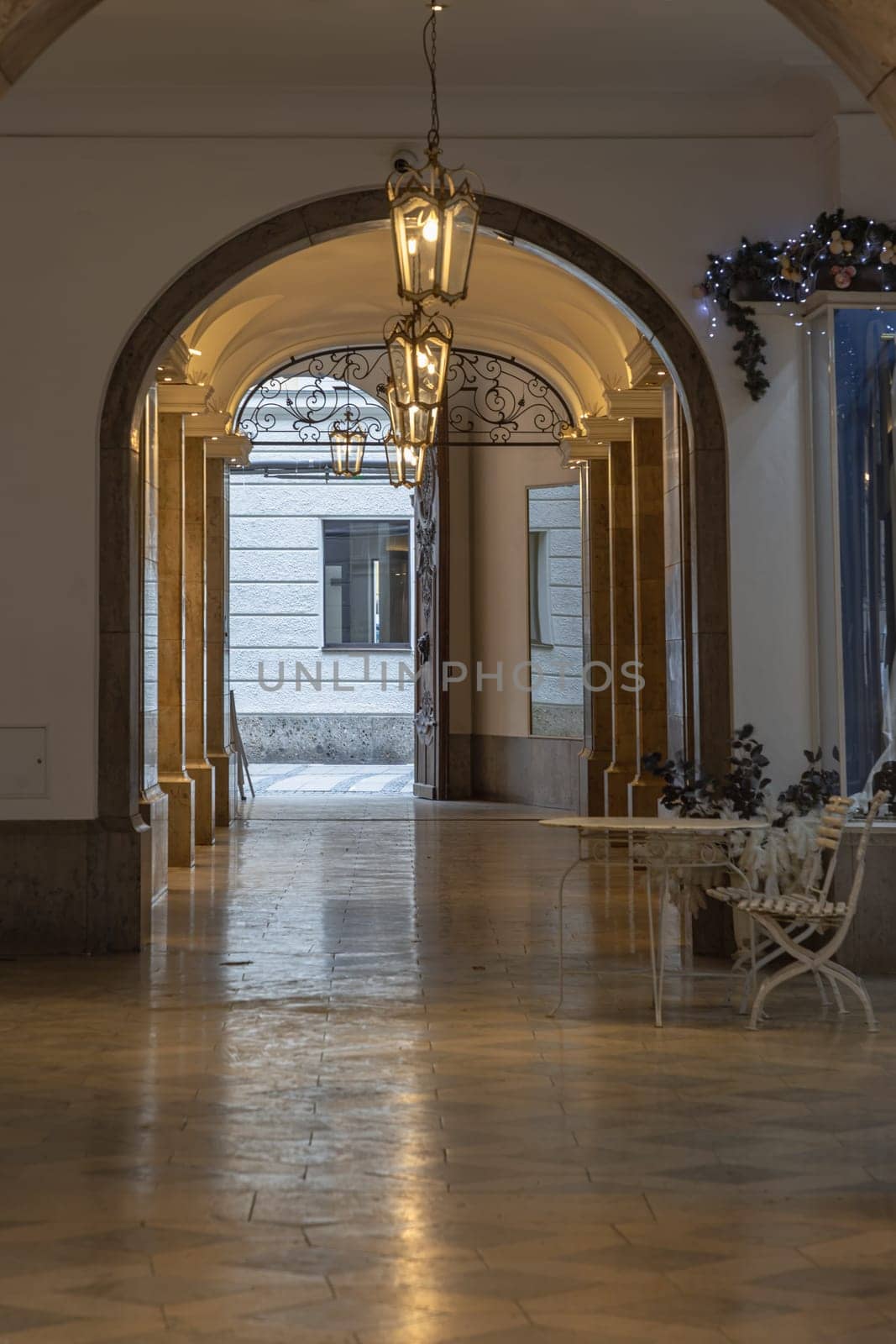 Munich, Germany - Dec 21, 2023 - Perspective view of Arches corridor with Antique lantern hanging from ceiling in Ancient building. Design elements of European architecture structure, Space for text, Selective focus.