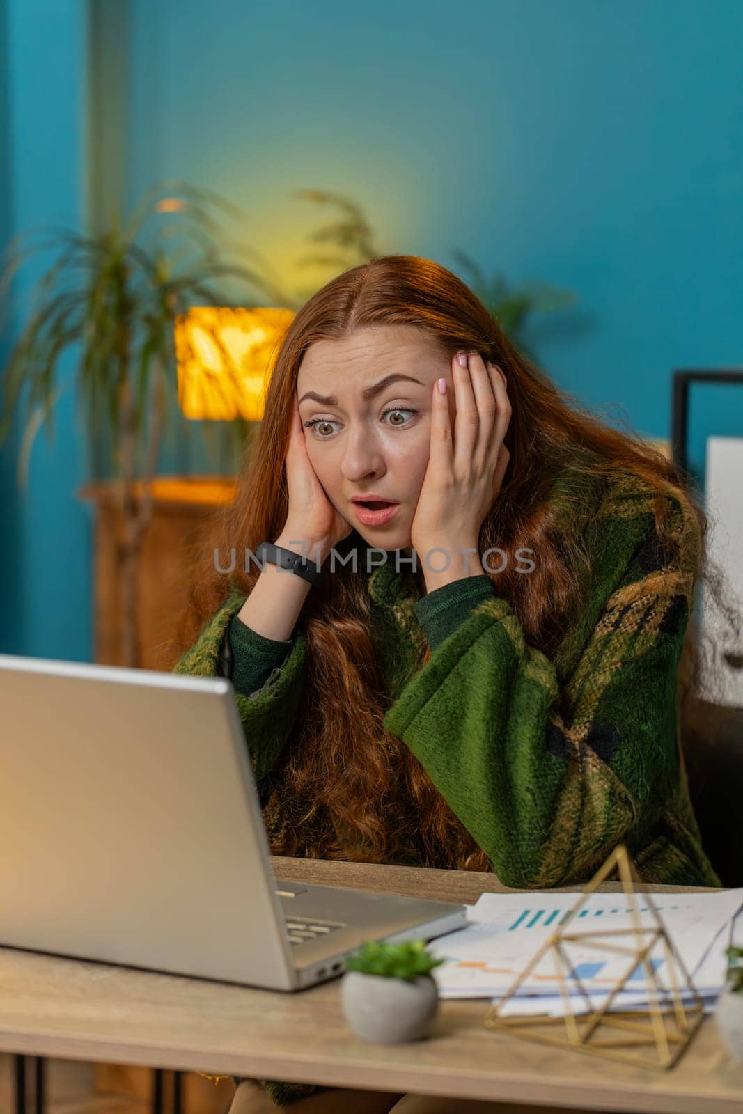 Displeased sad woman using laptop notebook typing browsing working loses becoming surprised sudden lottery results bad news fortune loss game fail computer virus. Girl at home office table. Vertical