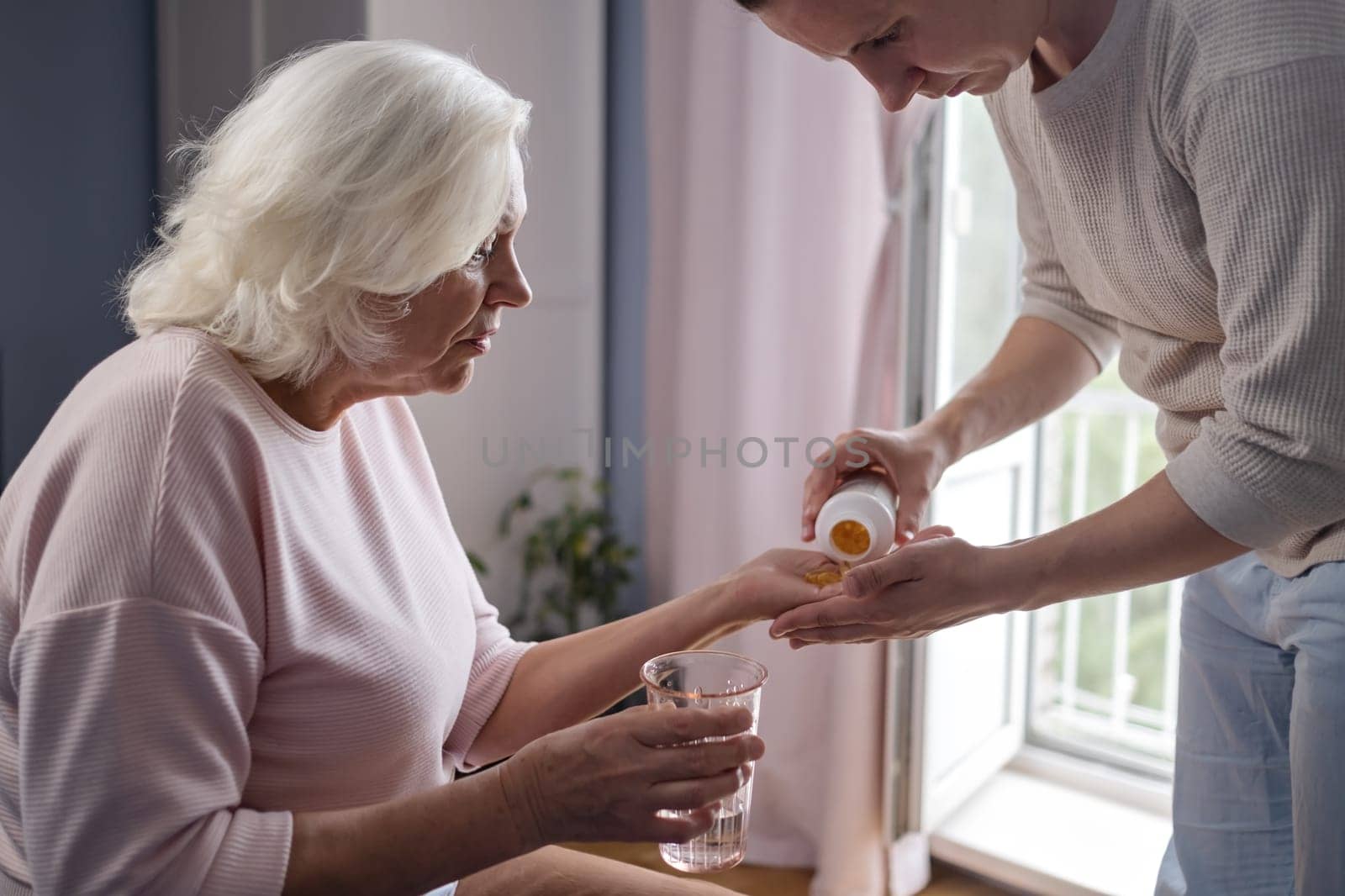 senior woman with glass water and pills. High quality photo