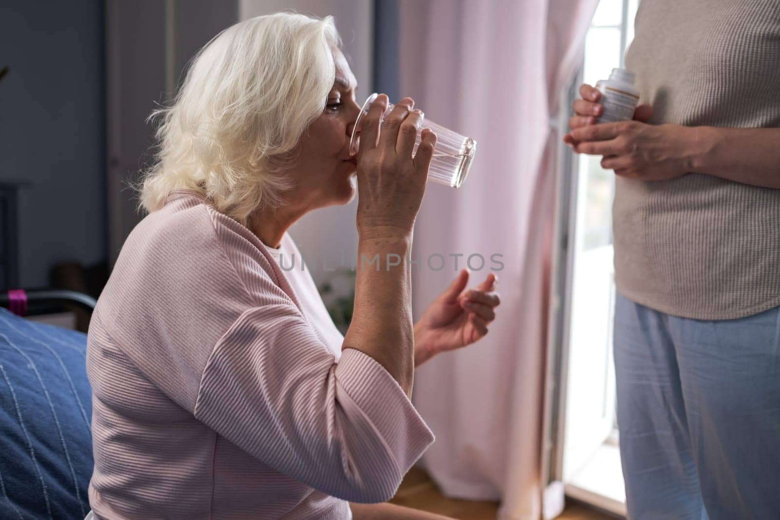senior woman with glass water and pills. High quality photo