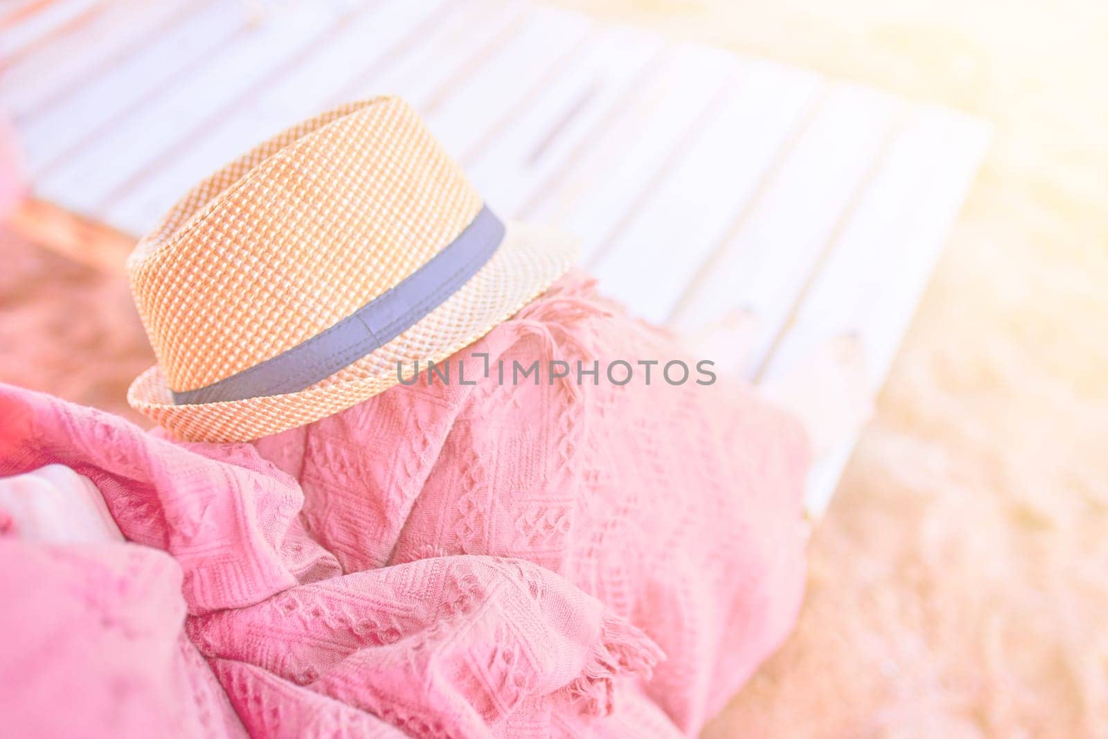 Straw hat on a hot day off on womans leg with plaid