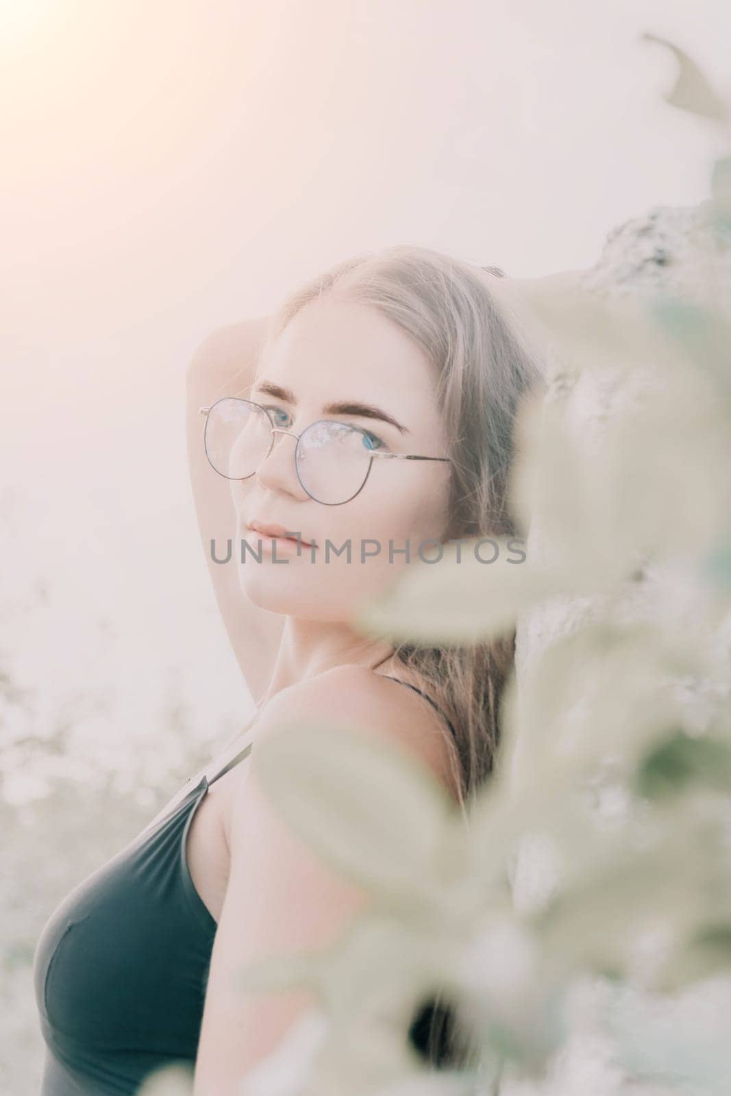 Woman travel sea. Young Happy woman in a long red dress posing on a beach near the sea on background of volcanic rocks, like in Iceland, sharing travel adventure journey