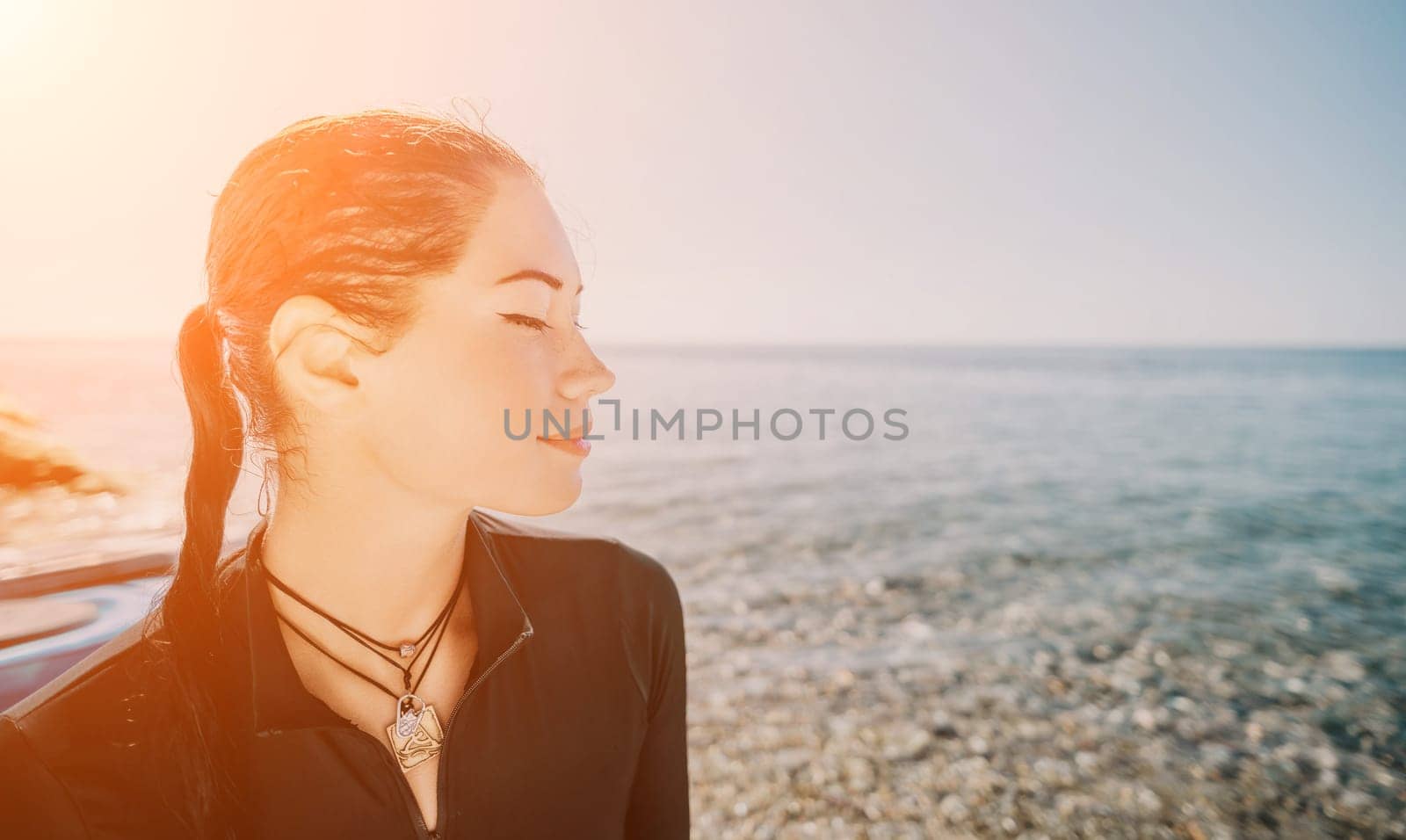 Woman travel sea. Young Happy woman posing on a beach near the sea on background of volcanic rocks, like in Iceland, sharing travel adventure journey