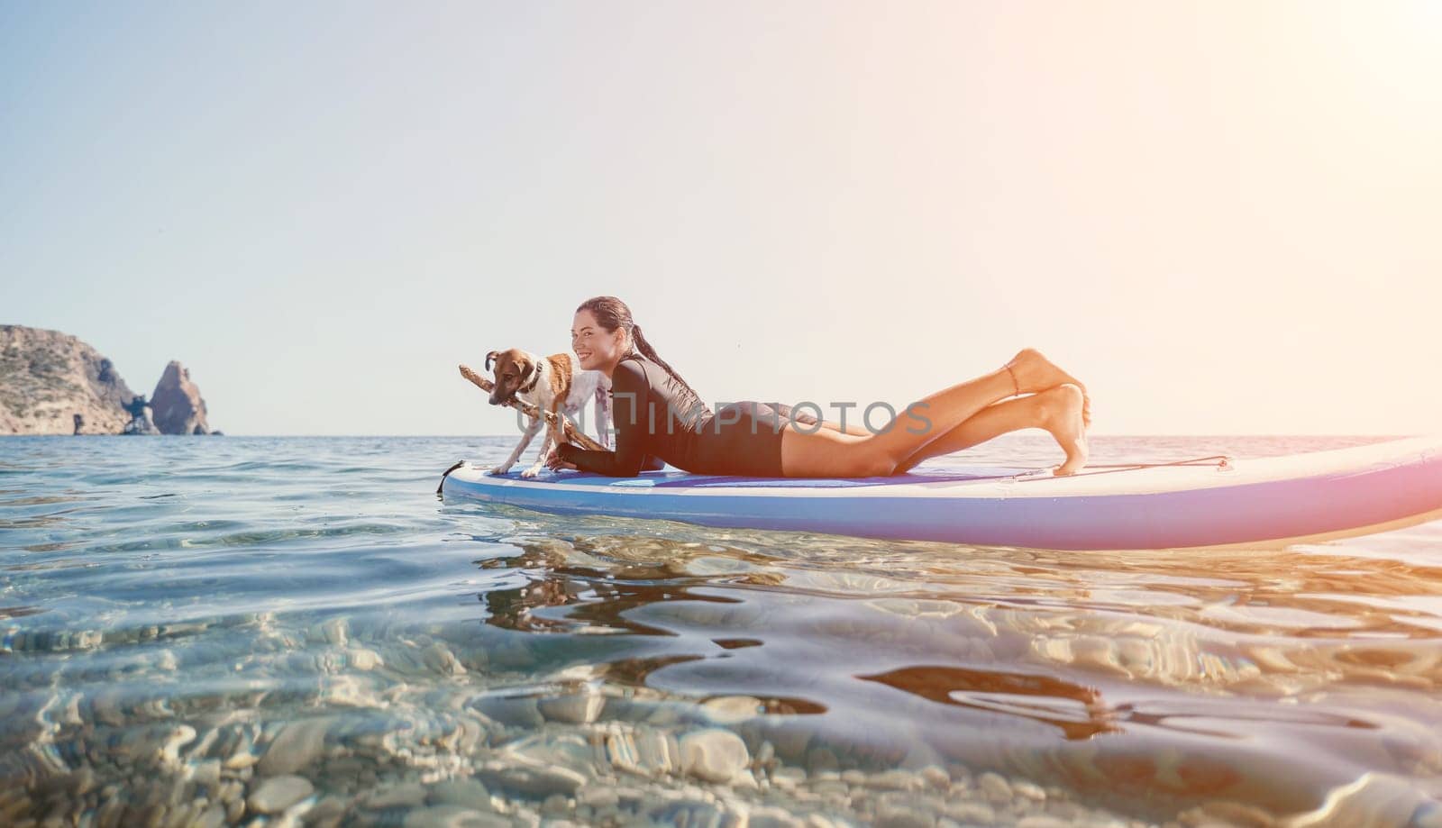 Sea woman sup. A happy positive woman in hat with family relaxing in sea, aerial back view of family on SUP board floating on calm water. Active lifestyle at sea. Summer vacation. Slow motion