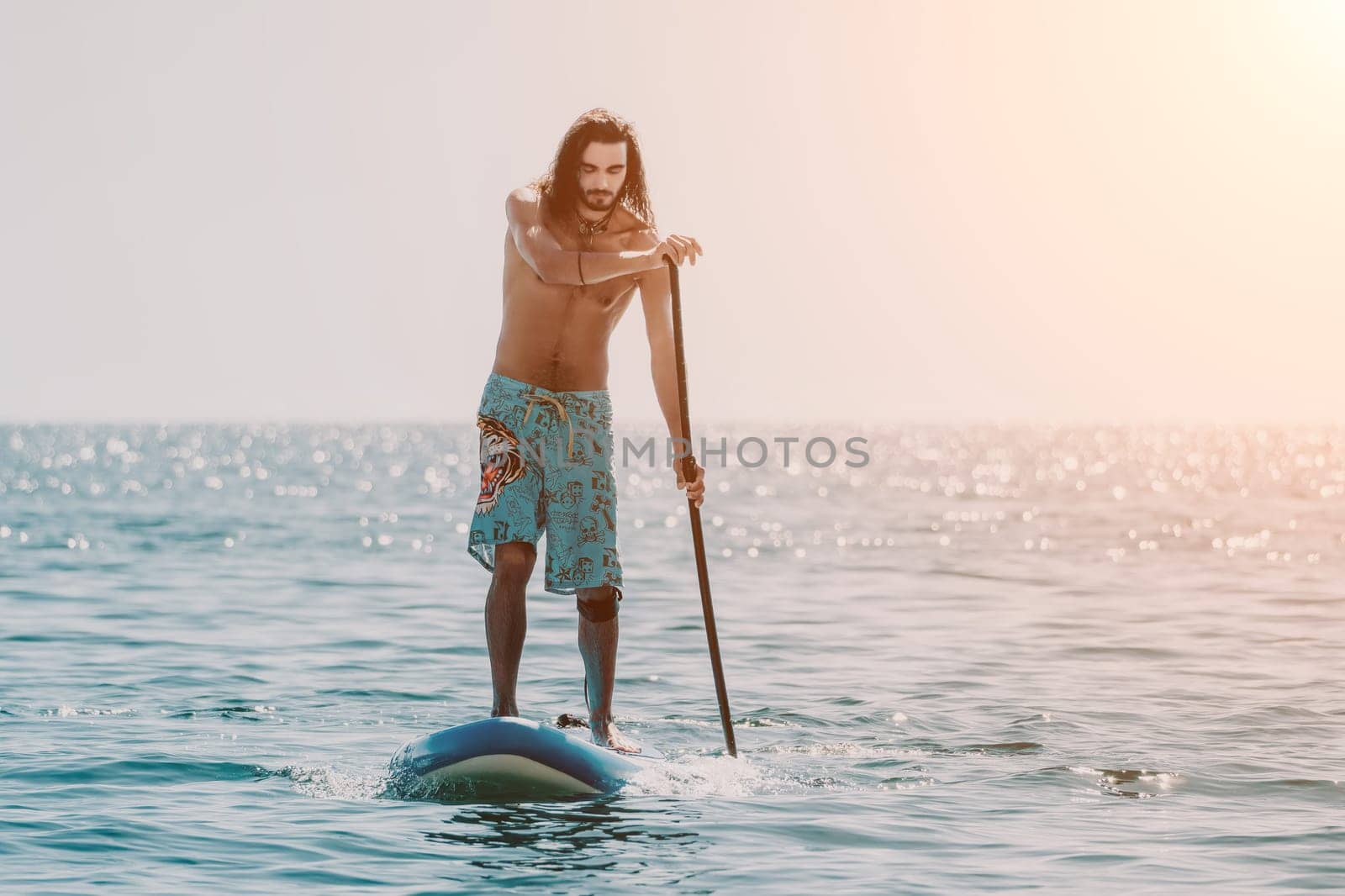 Man Sea Sup. Strong athletic man learns to paddle sup standing on board in open sea ocean on sunny day. Summer holiday vacation and travel concept. Aerial view. Slow motion.