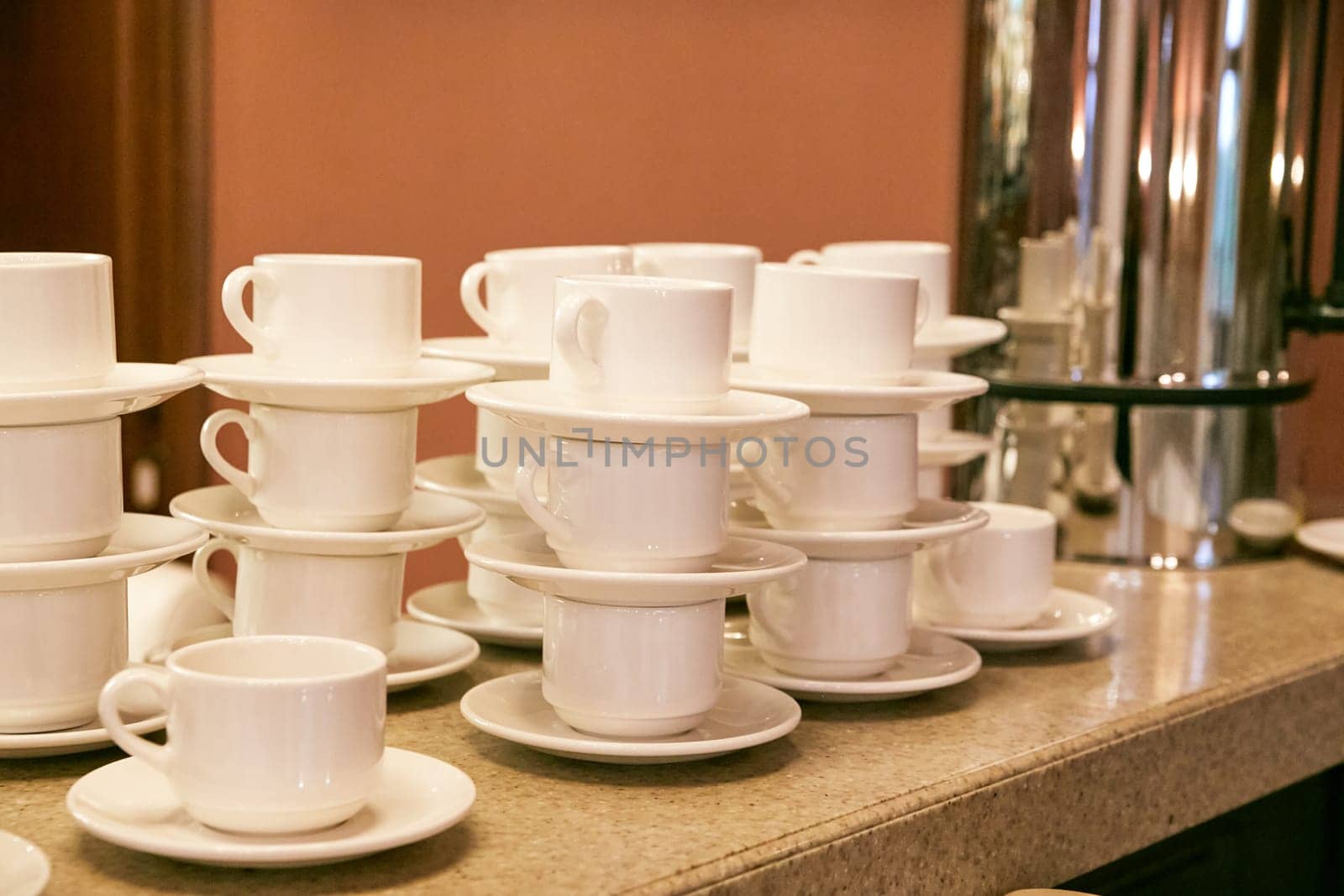 white cups and saucers on the bar counter in the cafe. coffee break. tea break. Table setting.