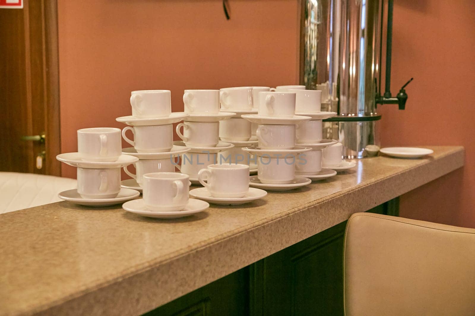 white cups and saucers on the bar counter in the cafe. coffee break. tea break. Table setting.