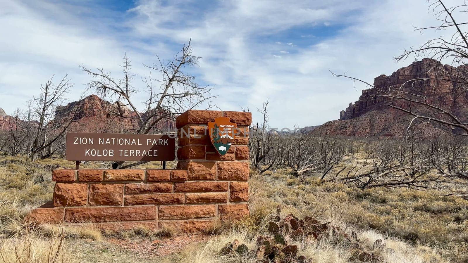 Virgin, Utah, USA - 02.26.2024: Zion National Park Kolob Terrace entrance sign. Scenic view of the national park sign with red rock mountains and canyons in the background.