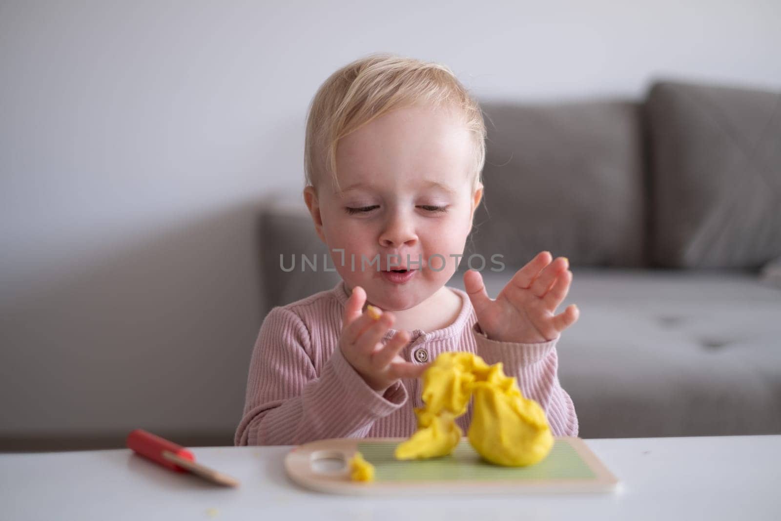 Portrait of smiling little toddler working with plasticine in art and craft class